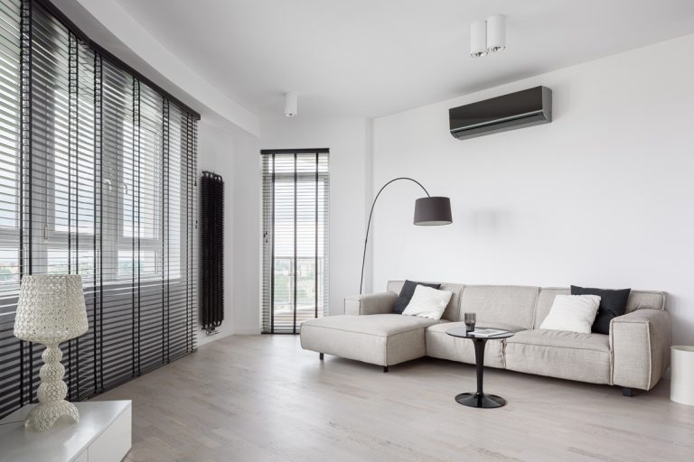 A modern living room with a white and gray color combination added with air conditioning on the upper right, Does Air Conditioning Add Moisture To The Air?
