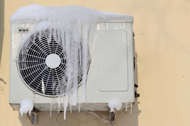 The air conditioner covered with icicles on a yellow wall, Air Conditioner Outside Unit Freezing Up - What Could Be Wrong?