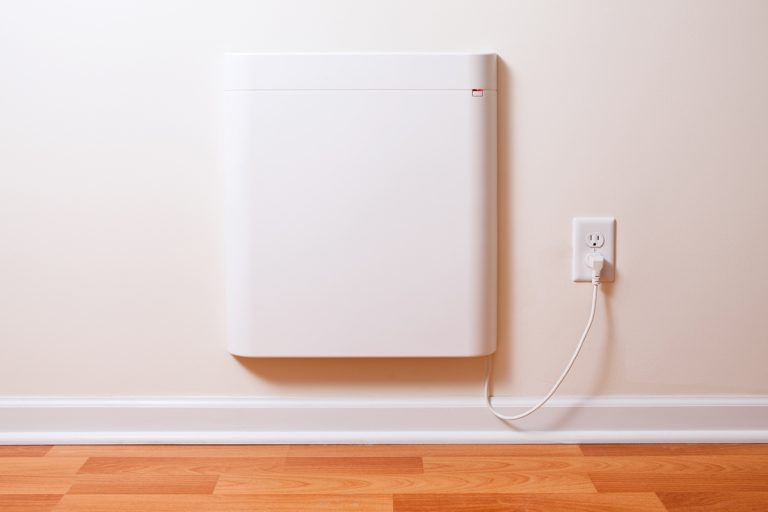 A convection heater placed near a baseboard on a white painted wall, Are Convection Heaters Better Than Baseboard Heaters?
