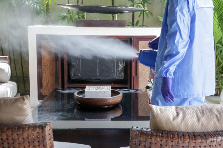 A man spraying gas ozone inside his house while wearing a PPE, Will an Ozone Generator Get Rid of Smoke Smell?