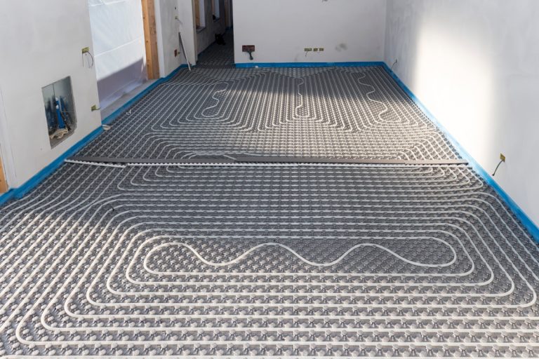 A radiant floor heating system on a small room with a control panel on the wall, Should I Turn Down Radiant Heat At Night?