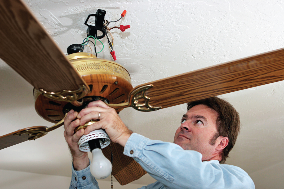 Electrician Removes wooden Ceiling Fan
