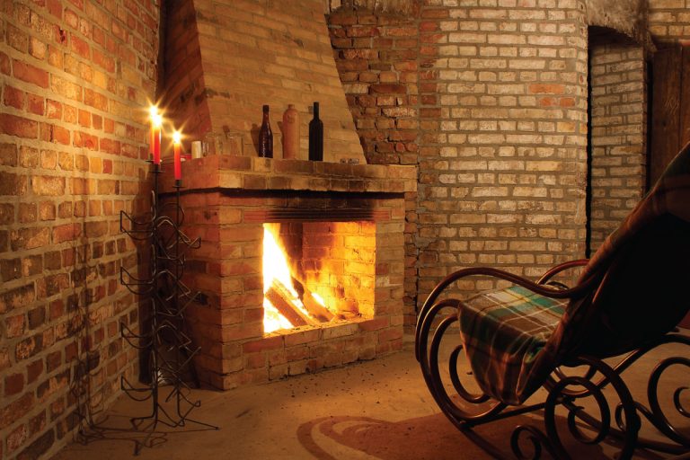 rocking chair by a brick fireplace with candles, types of fireplaces