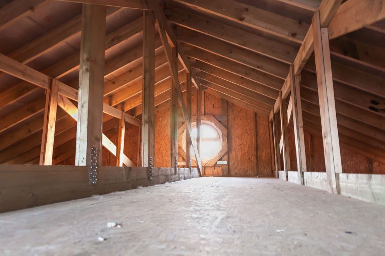 An attic with wooden frame roof membranes with an attic skylight with fan, Can You Run An Attic Fan With The AC On? [And should you?]