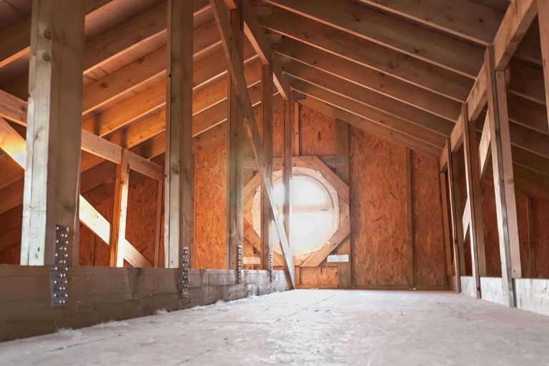 An attic of a house with visible wood membranes and an attic fan, Is An Attic Fan Necessary (Even With Ridge Vents)?