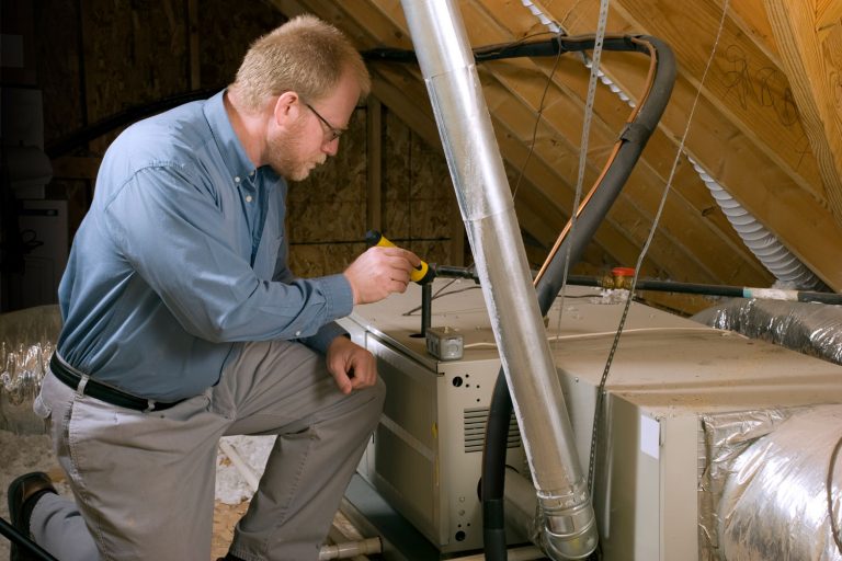 A repair man checking the furnace in the attic, Can You Put A Furnace In The Attic?