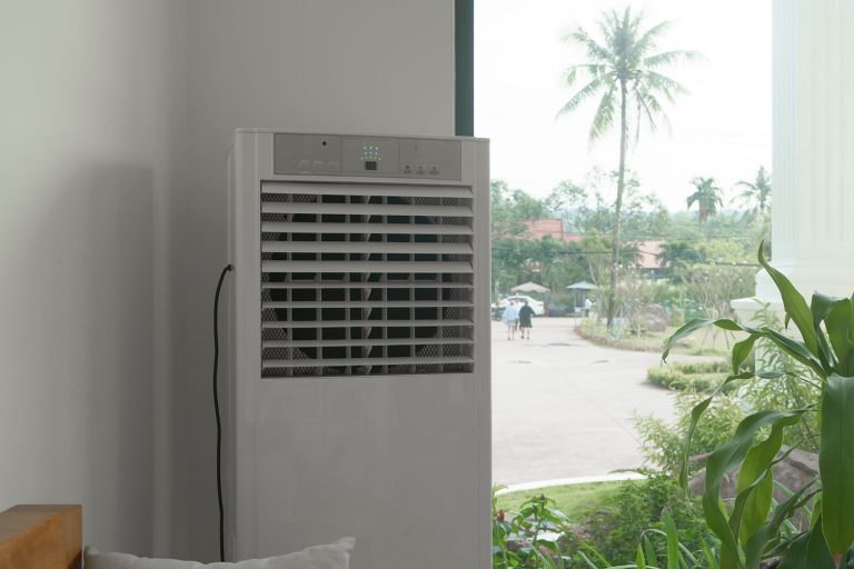 A cooler inside a living room placed next to a window for proper cooling, Can You Put Ice In An Evaporative Cooler?