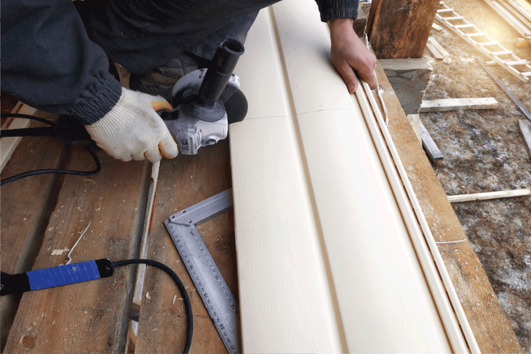 An employee cuts siding to the required size. Does Vinyl Siding Make A House Warmer