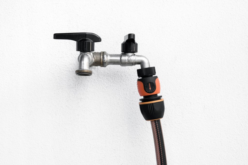 A double water faucet on a white background