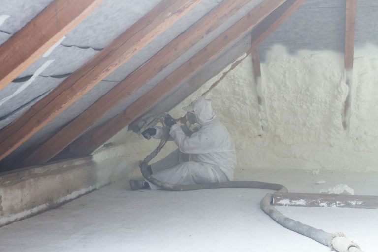 A home insulation specialist spraying insulation foam on the roof of the attic, Does Foam Insulation Need A Vapor Barrier?