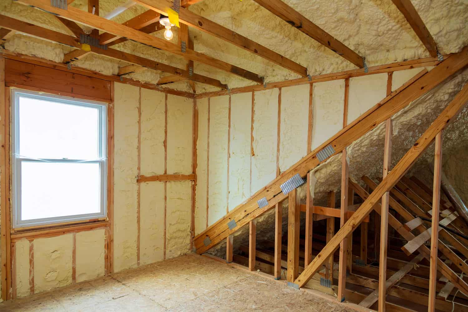 A room at a newly constructed home is sprayed with liquid insulating foam, How To Insulate Existing Interior Walls