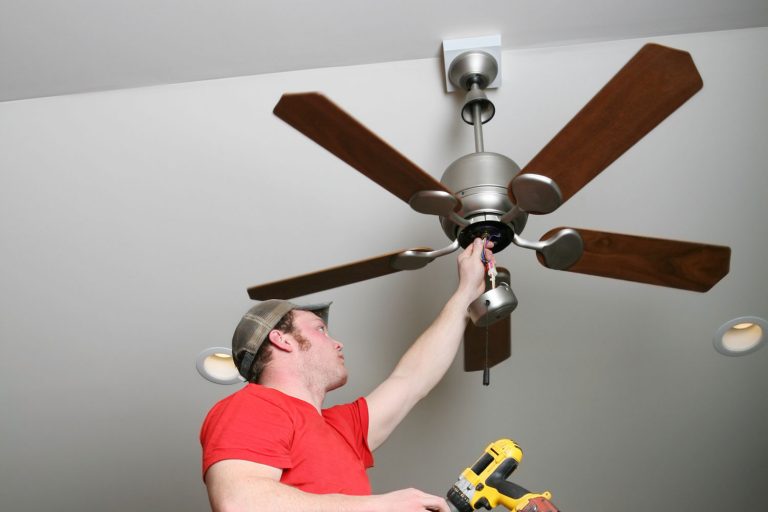 Electrician installing energy-saving ceiling fan on home addition job, How To Install A Ceiling Fan On A Sloped Ceiling