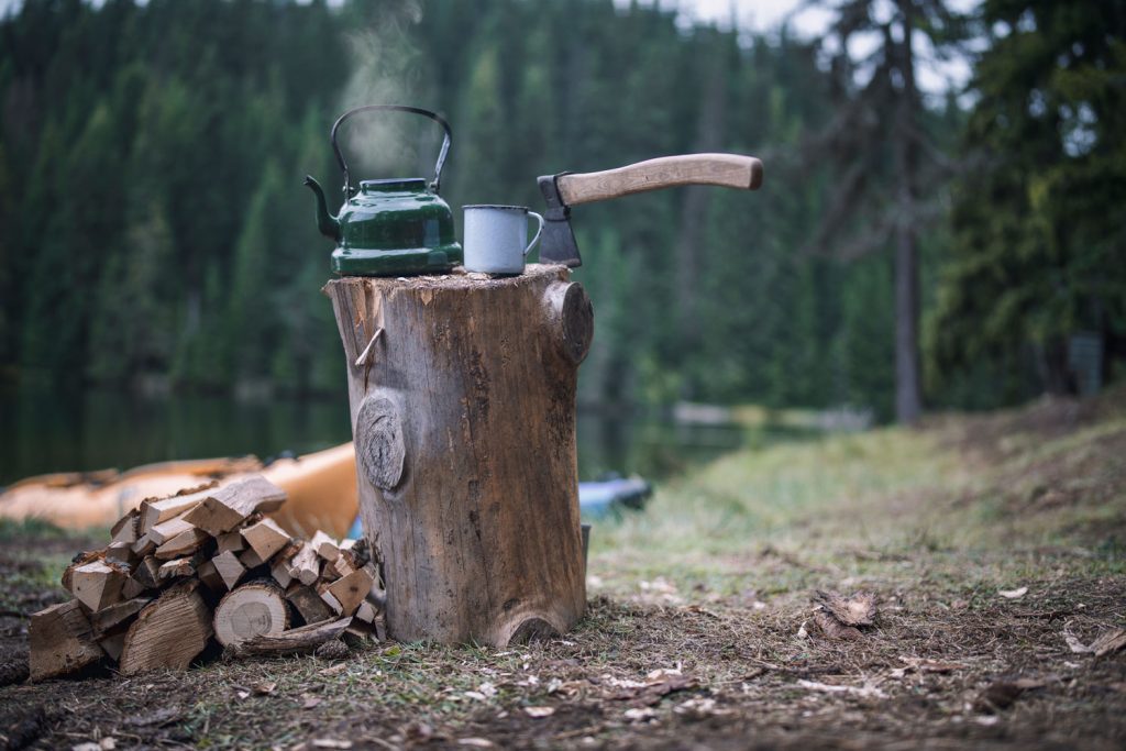 A log table with a pot brewing coffee