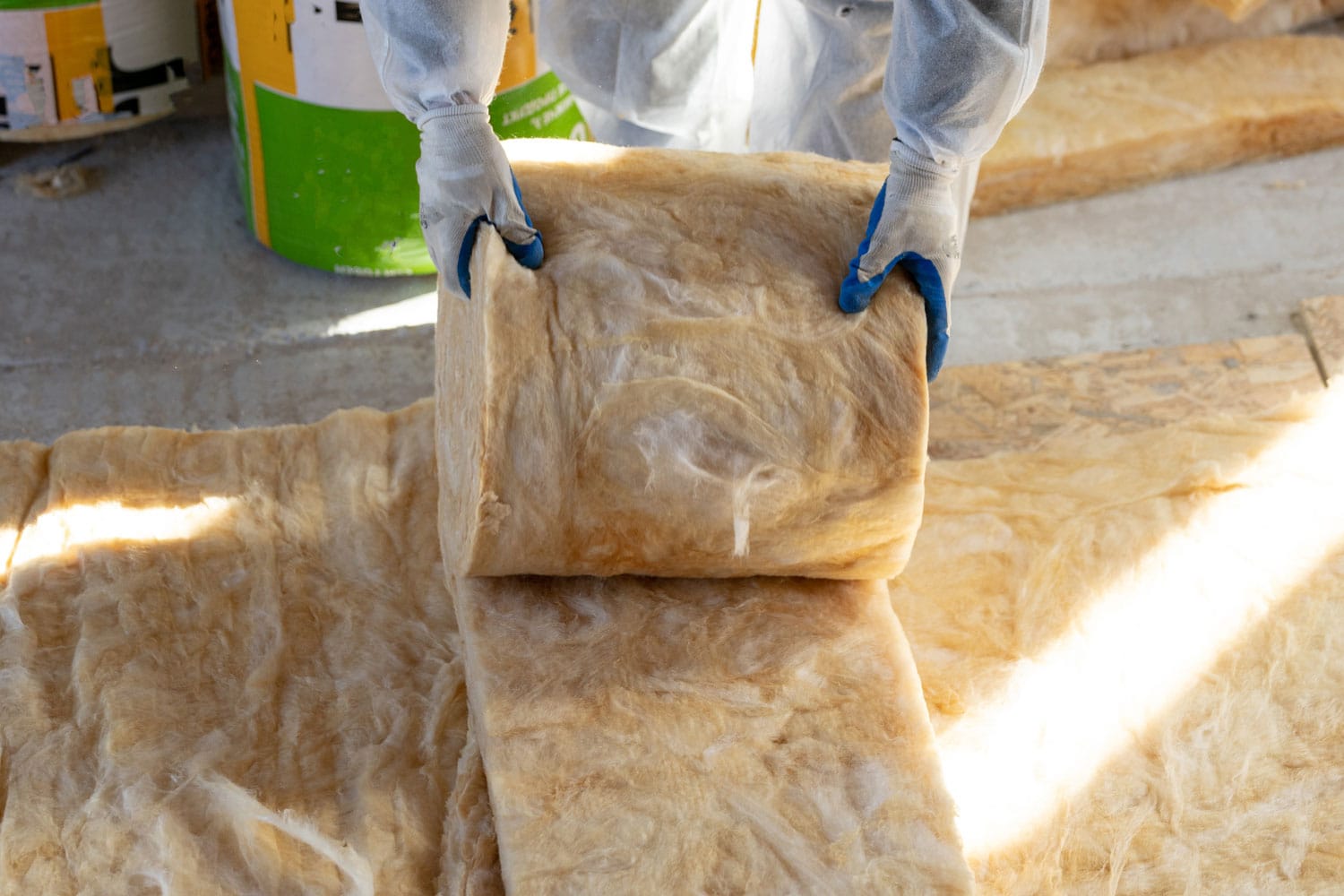 A worker unrolling rockwool insulation for the atticA