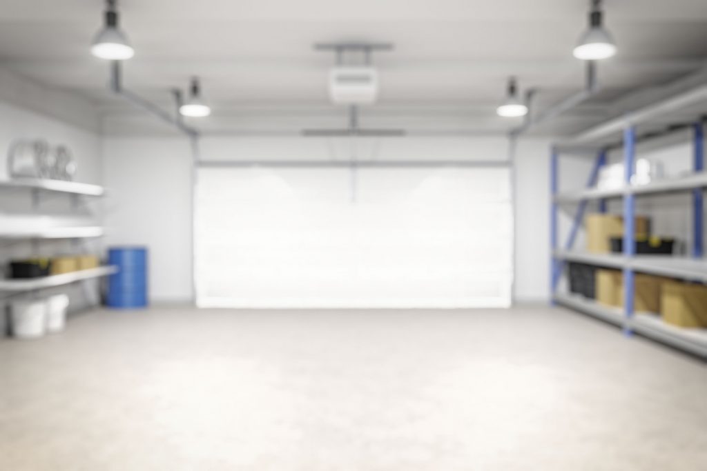 A blurred out empty garage with pot lights and other mechanical equipment's on the side
