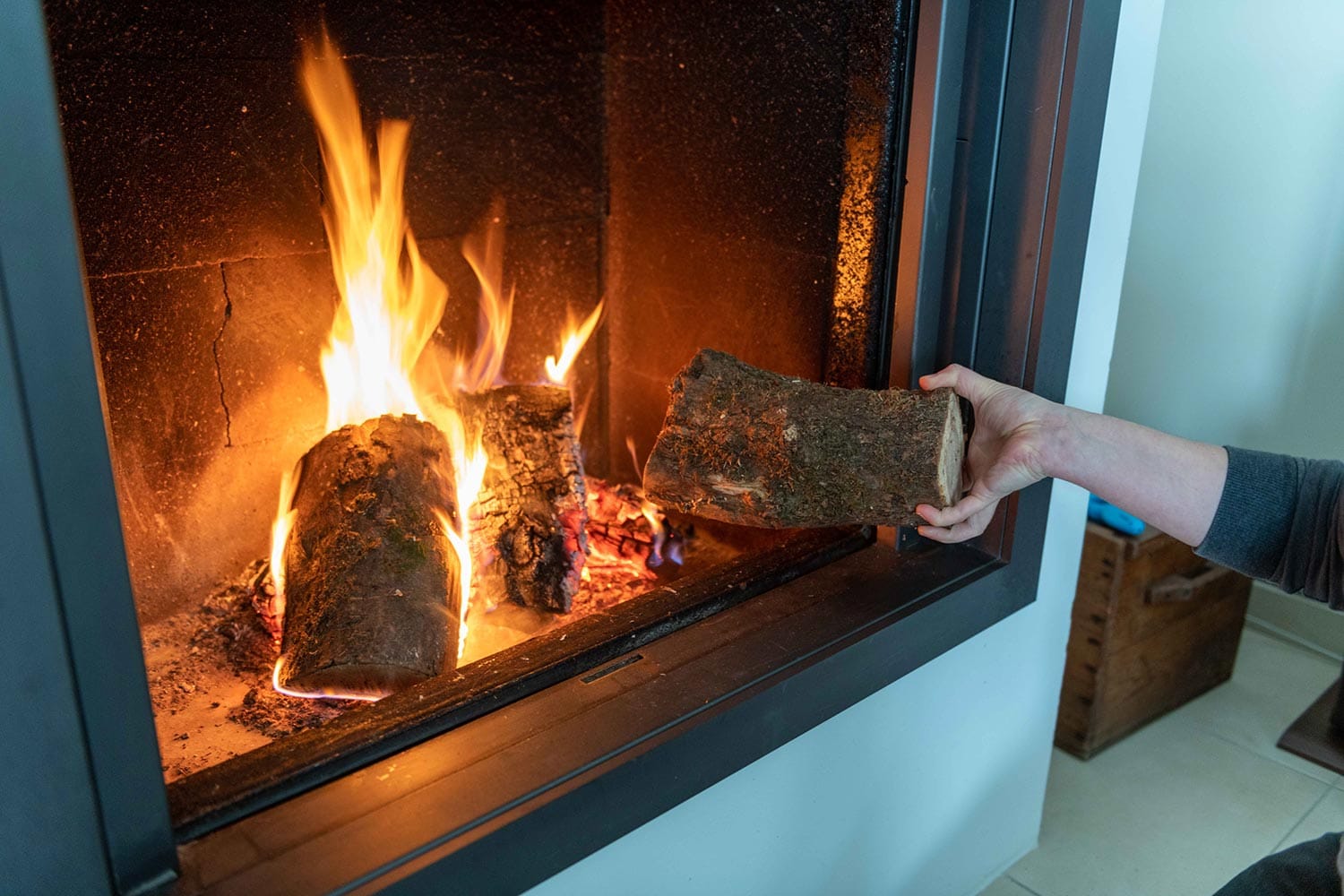 Woman putting a log in her fireplace