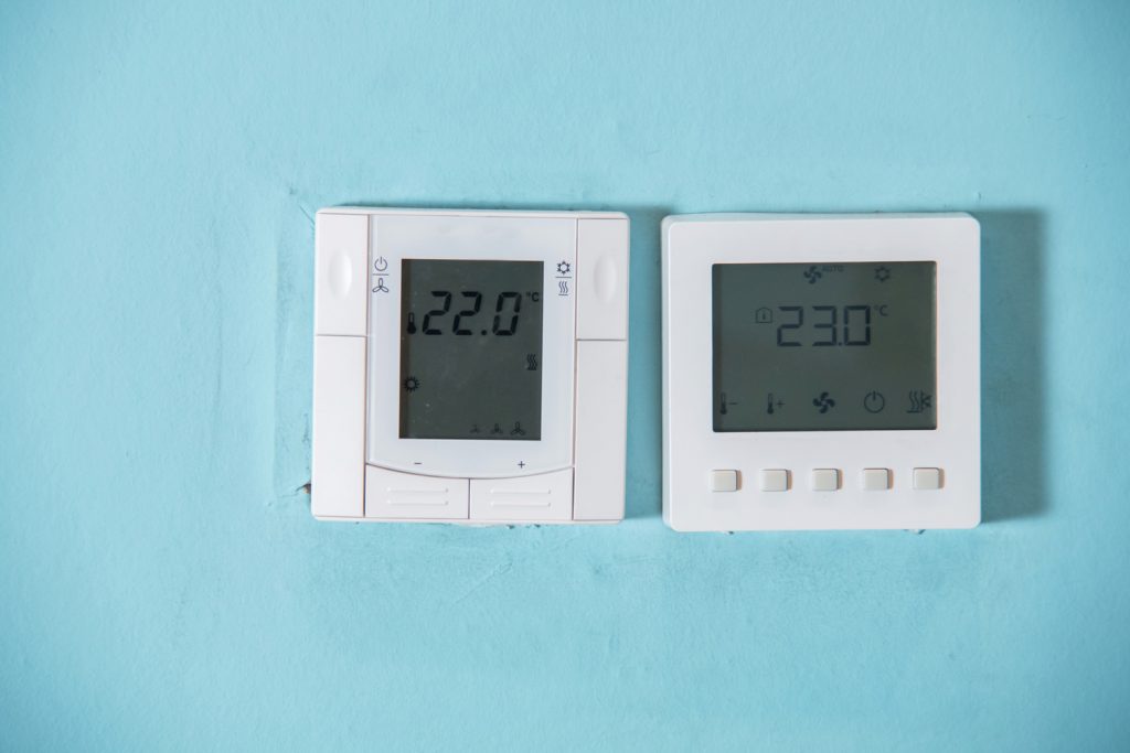 A Honeywell programmable thermostat to control the air conditioner and heater in a home. air conditioning system control unit on wall.