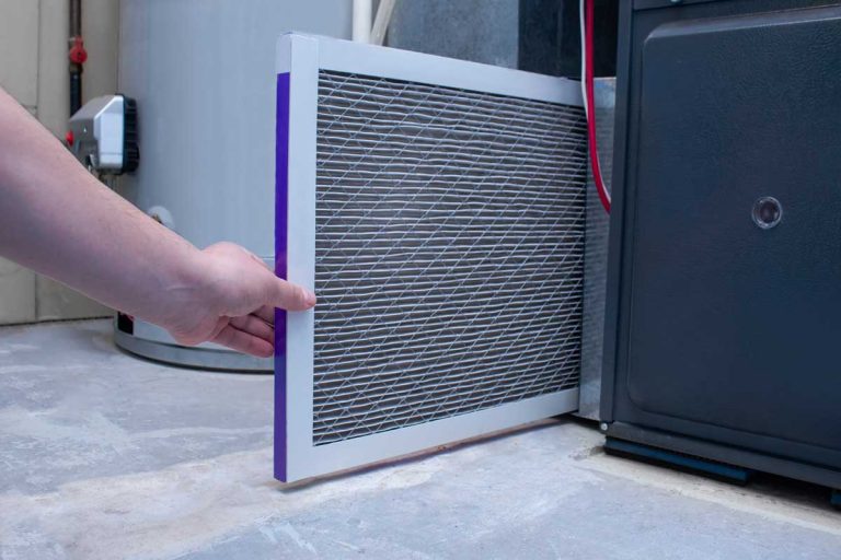 A person changing an air filter on a high efficiency furnace, Do Electric Furnaces Have Filters?