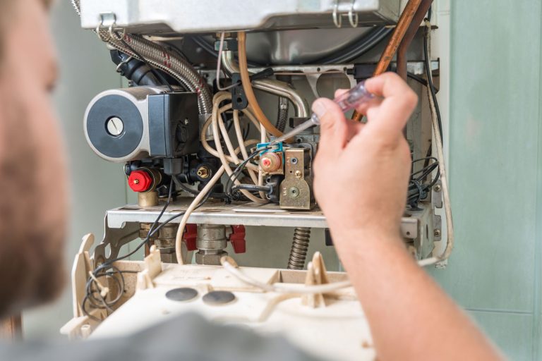 A worker repairing the gas furnace, How Long Does An Electric Furnace Last?