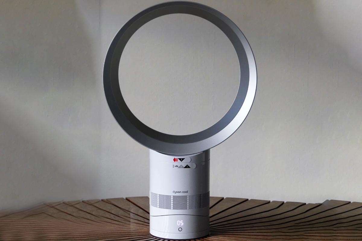 Dyson cool AM06 white desk fan placed on circular wooden table, Can A Dyson Fan Detect Mold And Remove It?