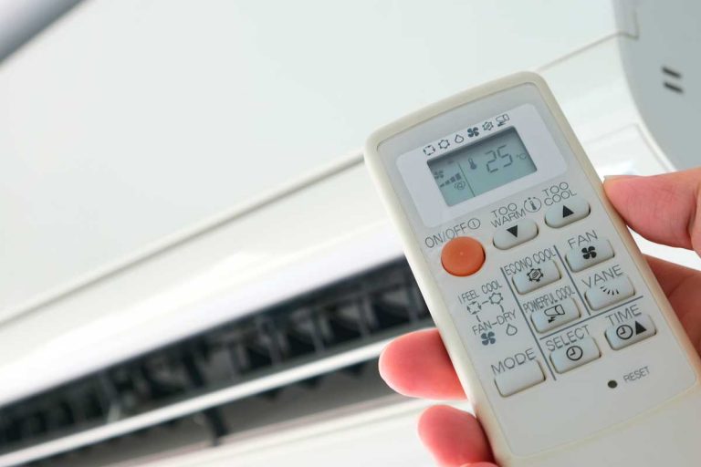 Hand using remote control open the air conditioner, AC Thermostat Keeps Shutting Off — What To Do?
