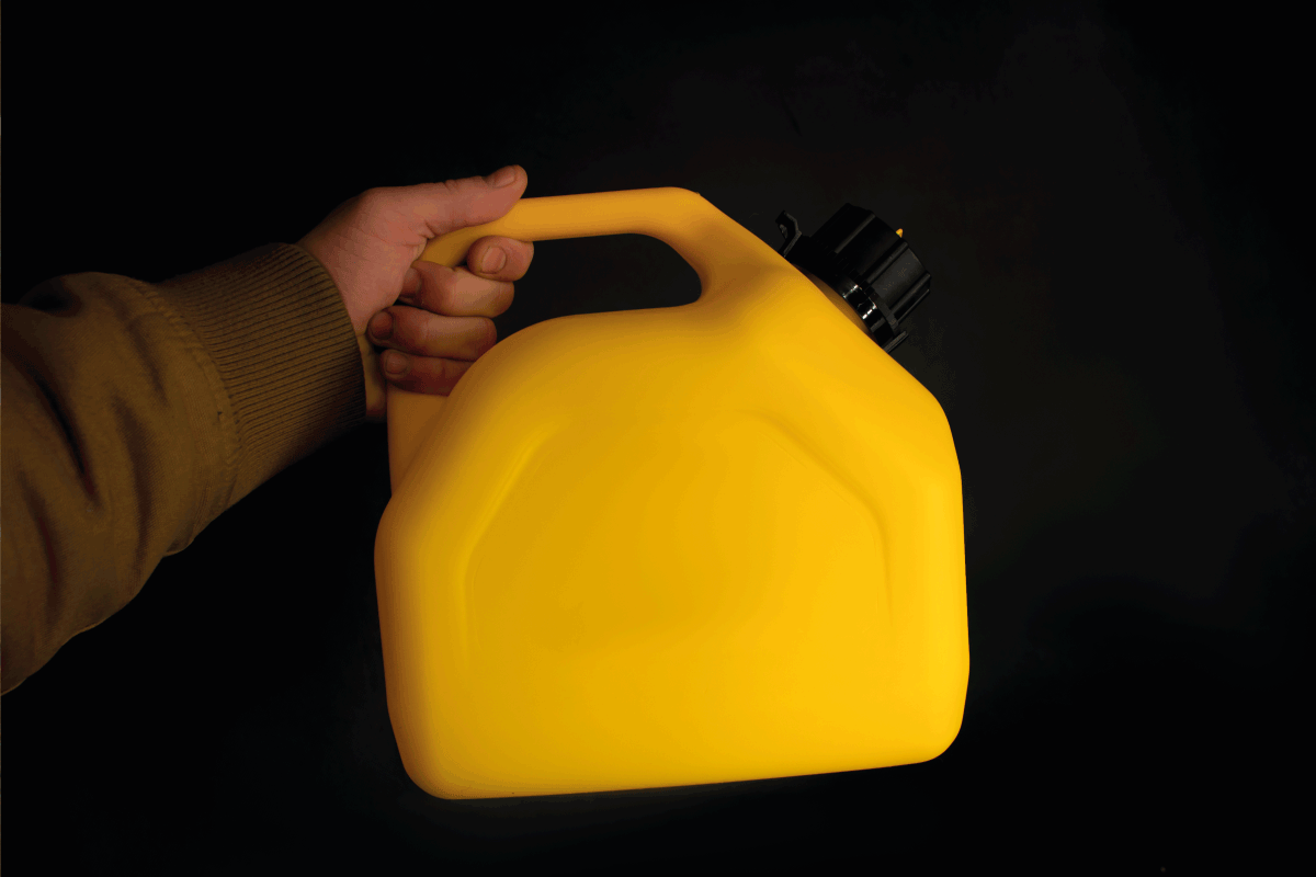 Man holds a yellow plastic jerrican for diesel fuel in his hand on a black background. Can You Put Diesel In An Oil Furnace