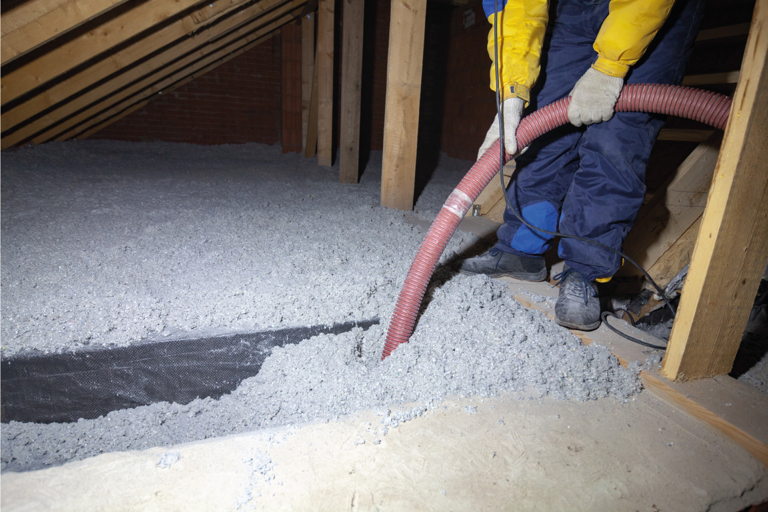 Spraying cellulose insulation in the attic of a house. Insulation of the attic or floor in the house