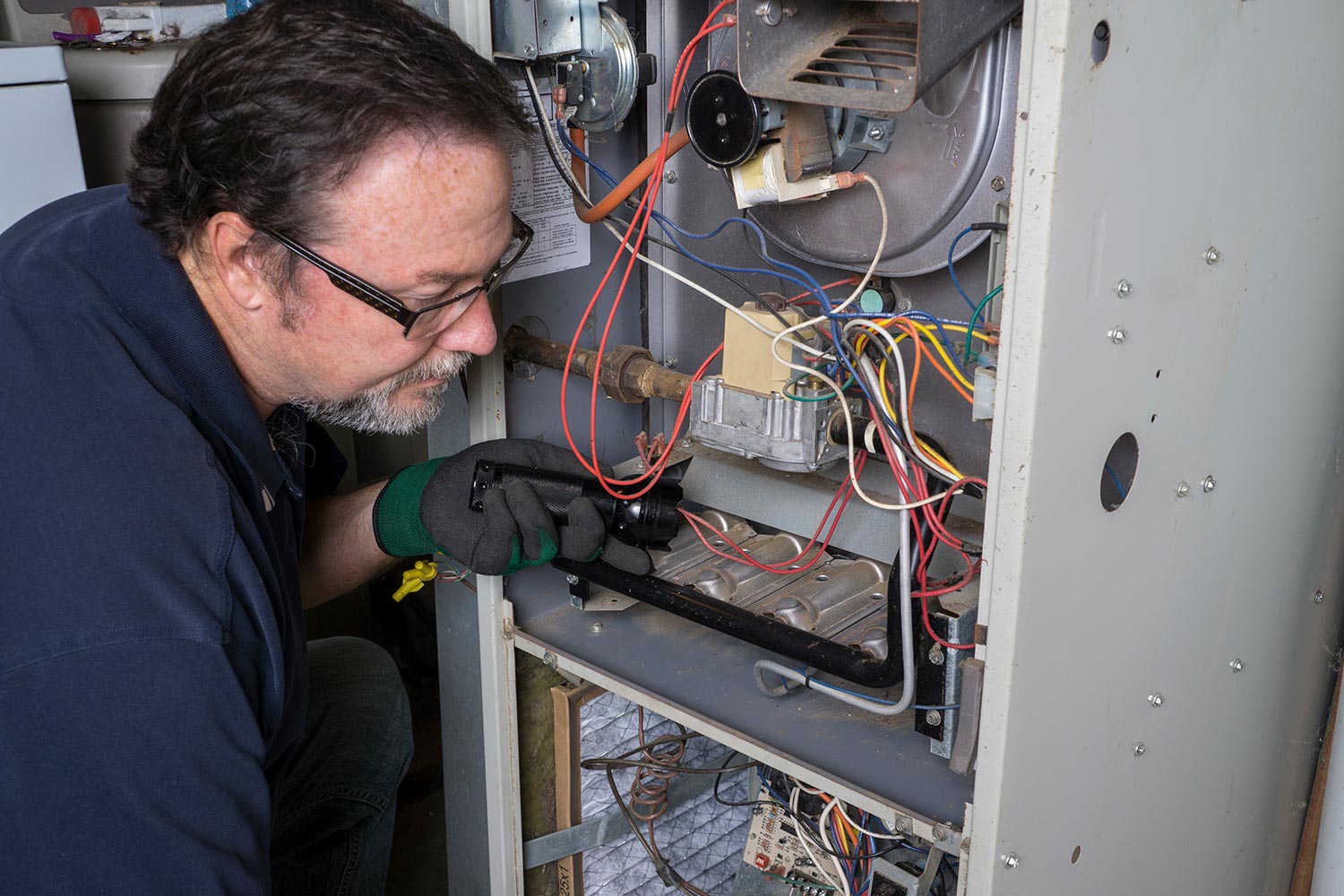 Technician looking over s gas furnace