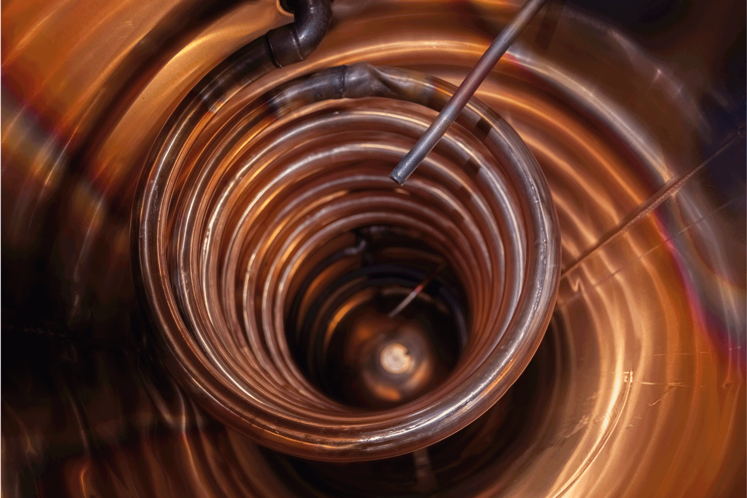 A copper coil winds its way through a hot water cylinder or tank. Hot water from the boiler, furnace, hot water solar thermal panels or other heat source travels through the coil
