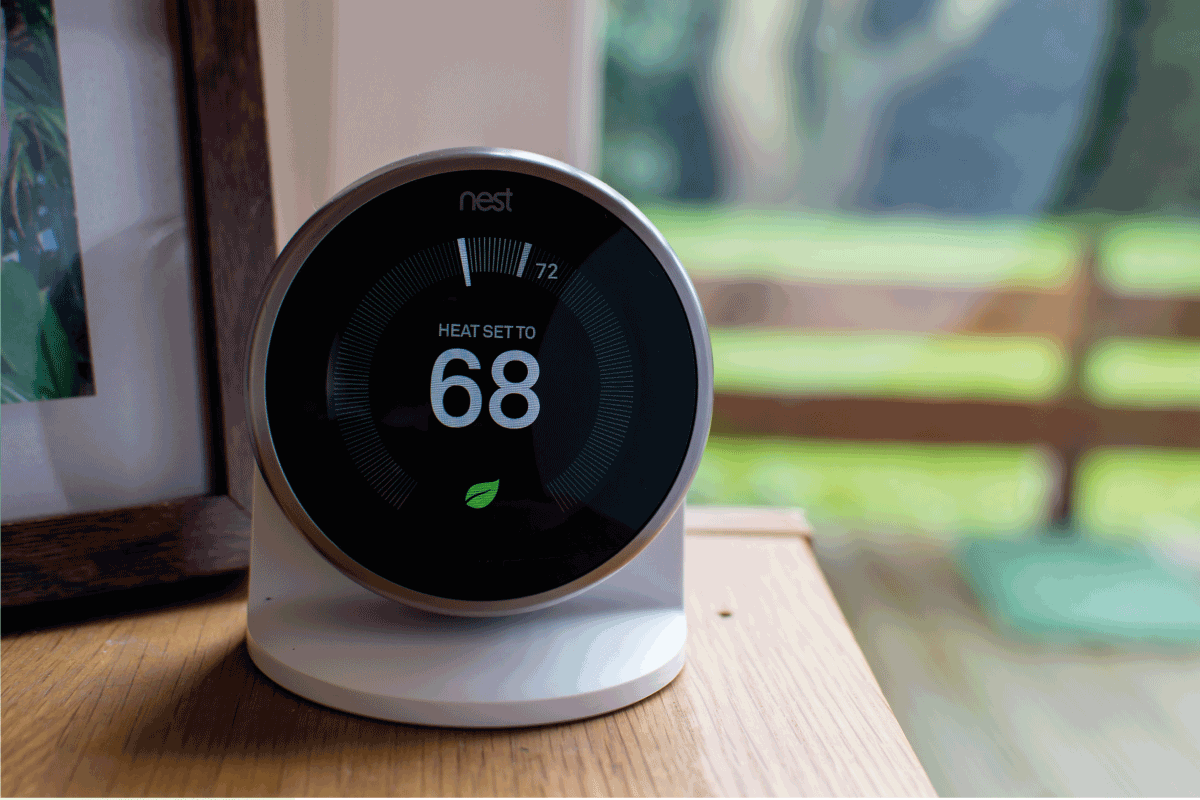 google nest device with dark screen on top of the wooden table. Does Nest Thermostat Work With Evaporative Cooler [And How To Connect Them]