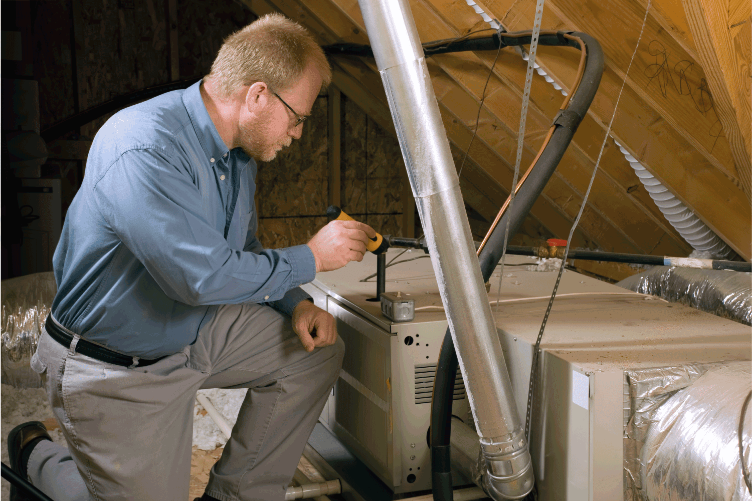 man doing furnace inspection at a suburban home