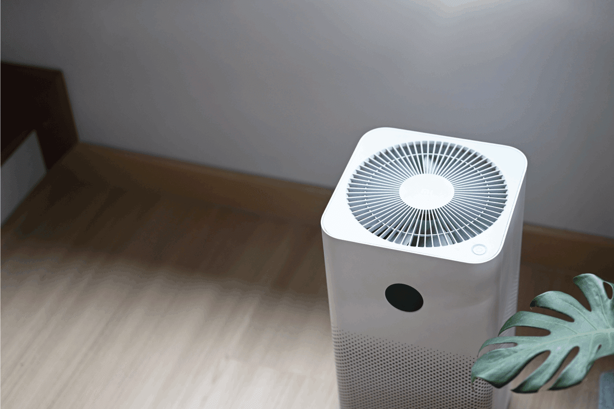 Air purifier in comfortable living room with house plant on the wooden floor. How Does An Air Washer Work