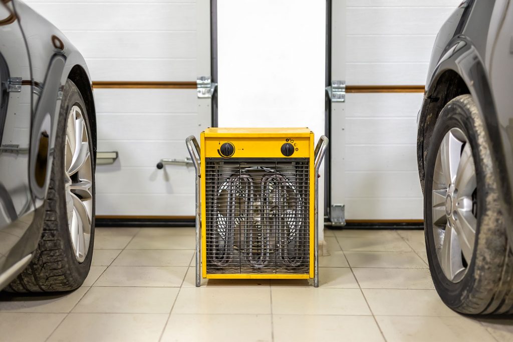 An industrial fan heater inside a two cargo garage