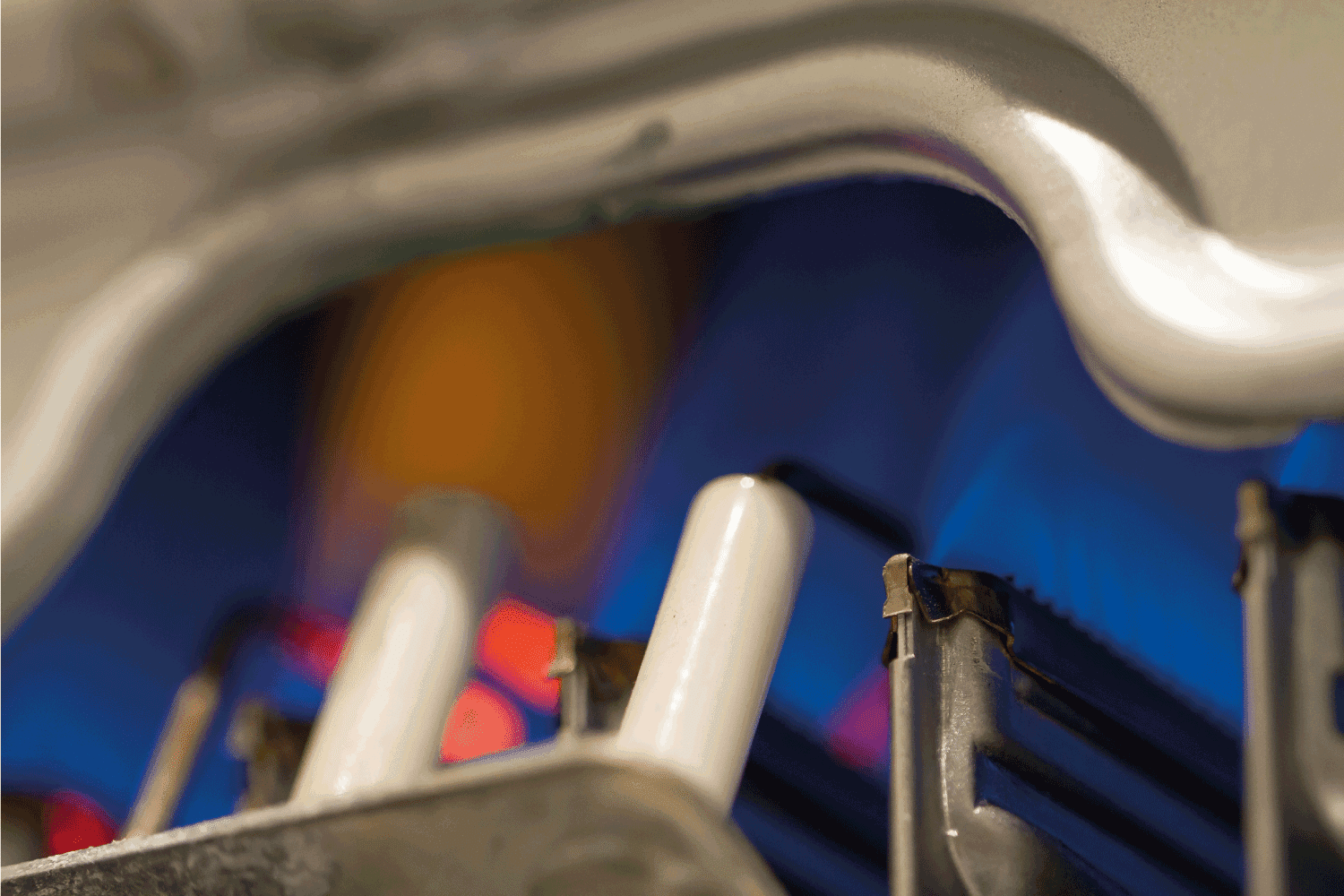 Close-up detail of a domestic gas water eater boiler, blue flames are visible inside