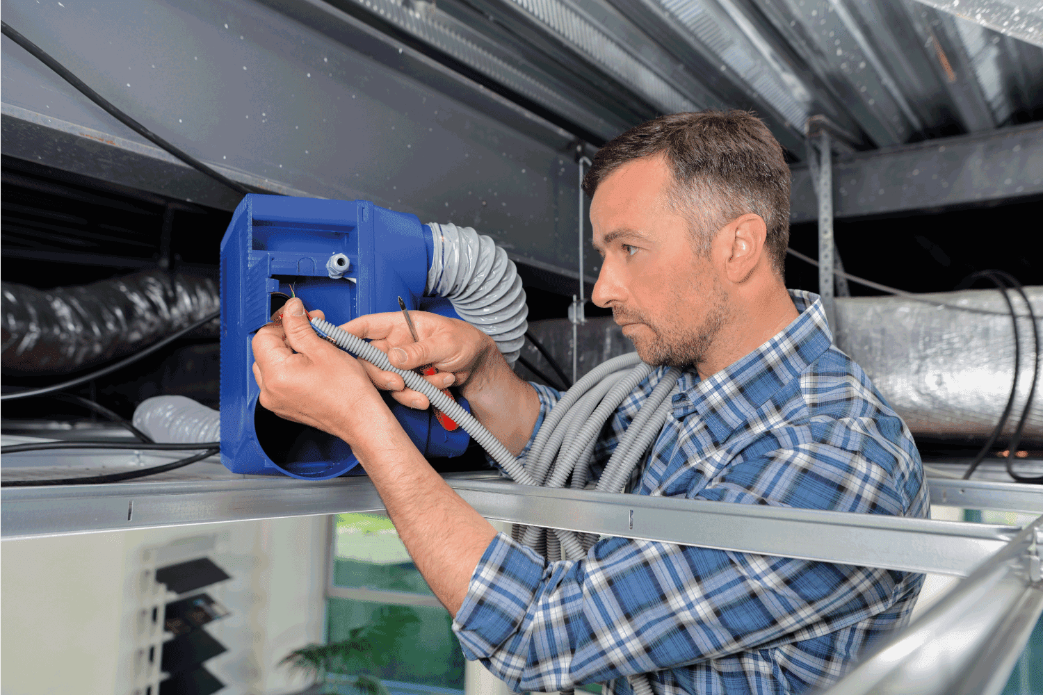 Man repairing ventilation system with bare hands