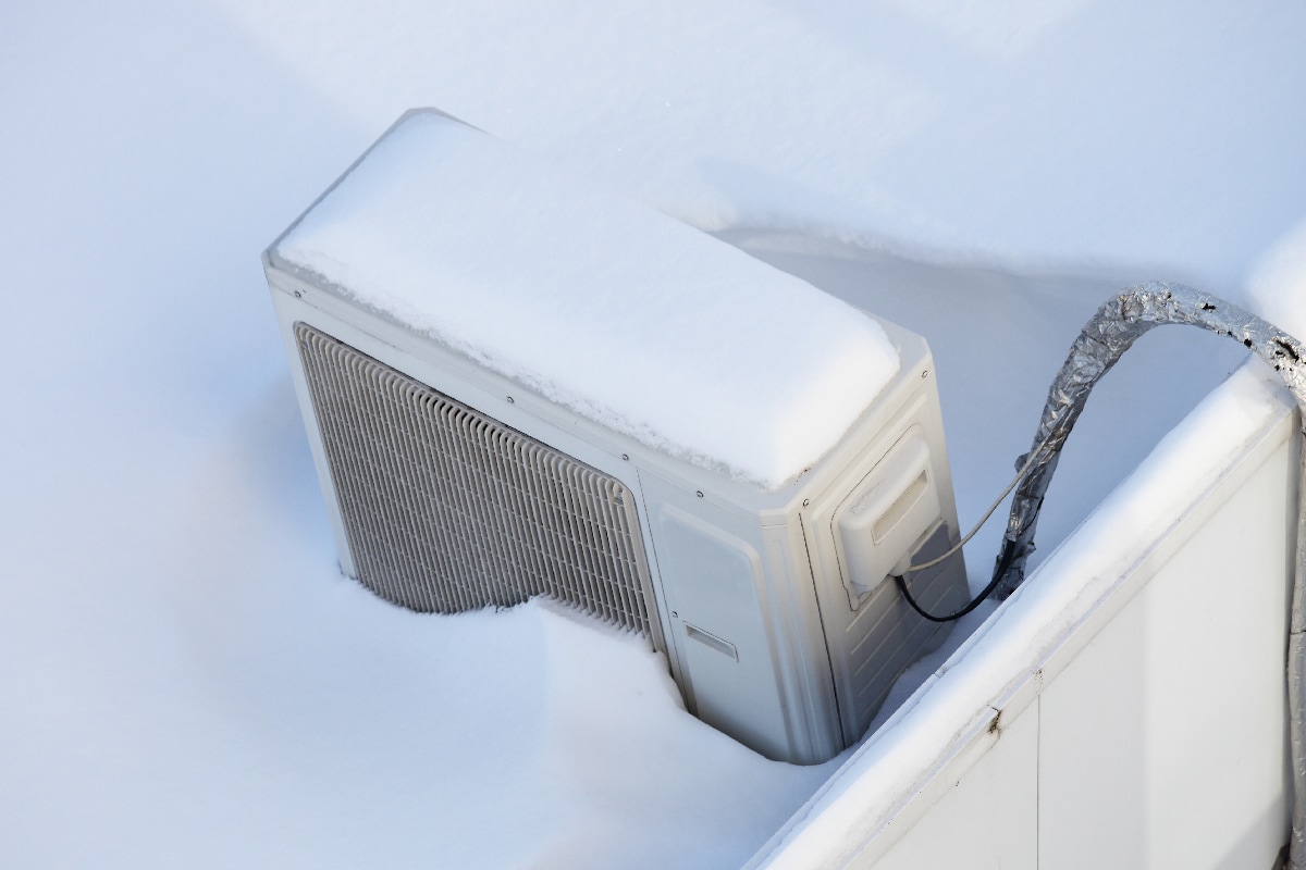 Snow covered air conditioner outdoor unit on roof top