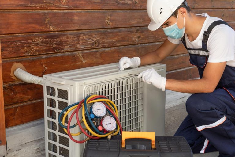 A technician in a disposable protective medical mask and gloves repairing an air conditioner, Should You Tip Furnace And HVAC Installers?