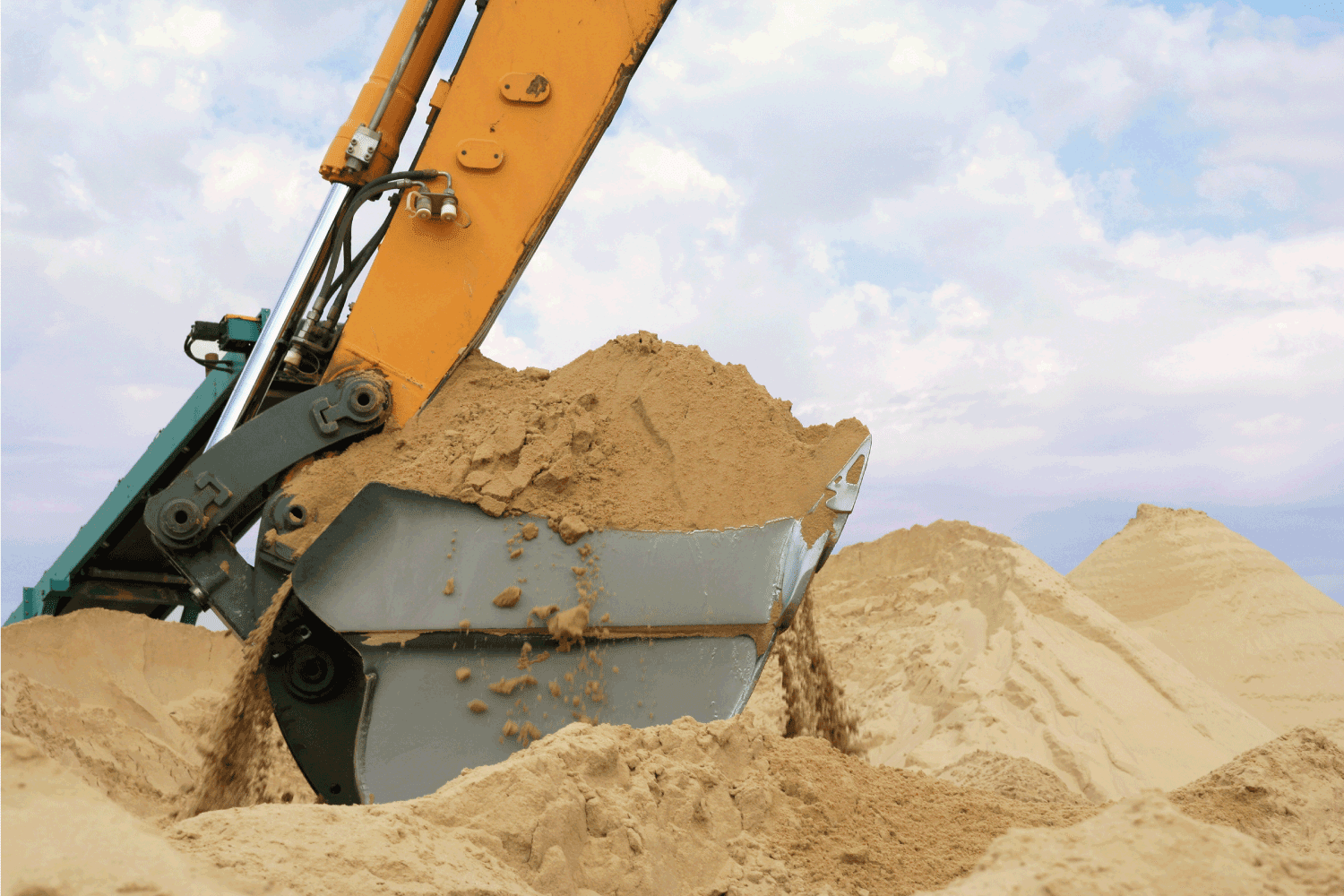 mechanical excavator bucket shoveling sand