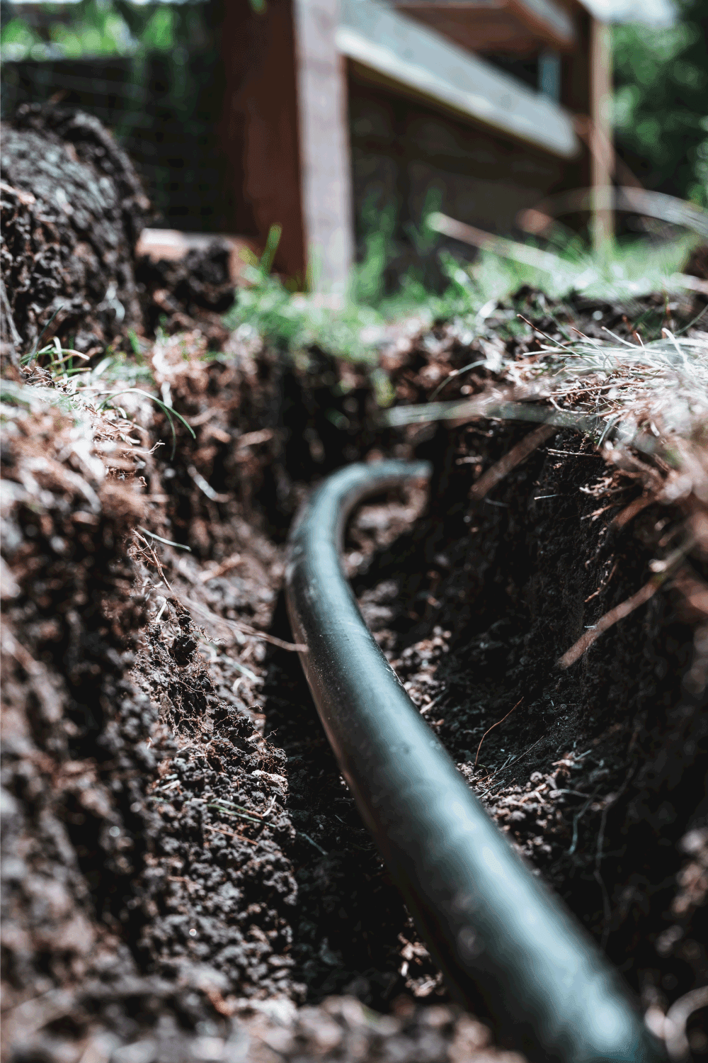 open trenched with a black sprinkler water line being repaired