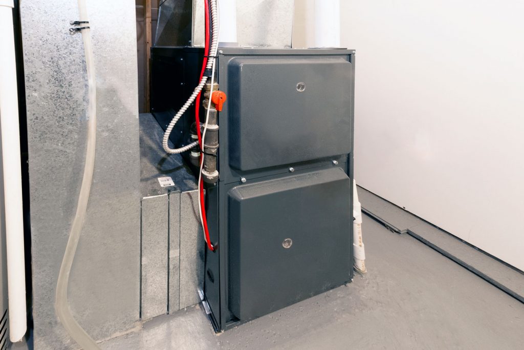 A black colored Goodman furnace with wirings on the side