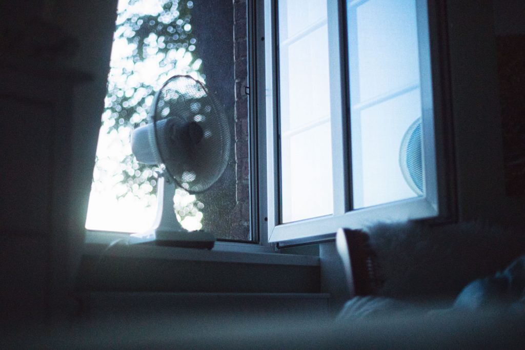 An electric fan placed near the window