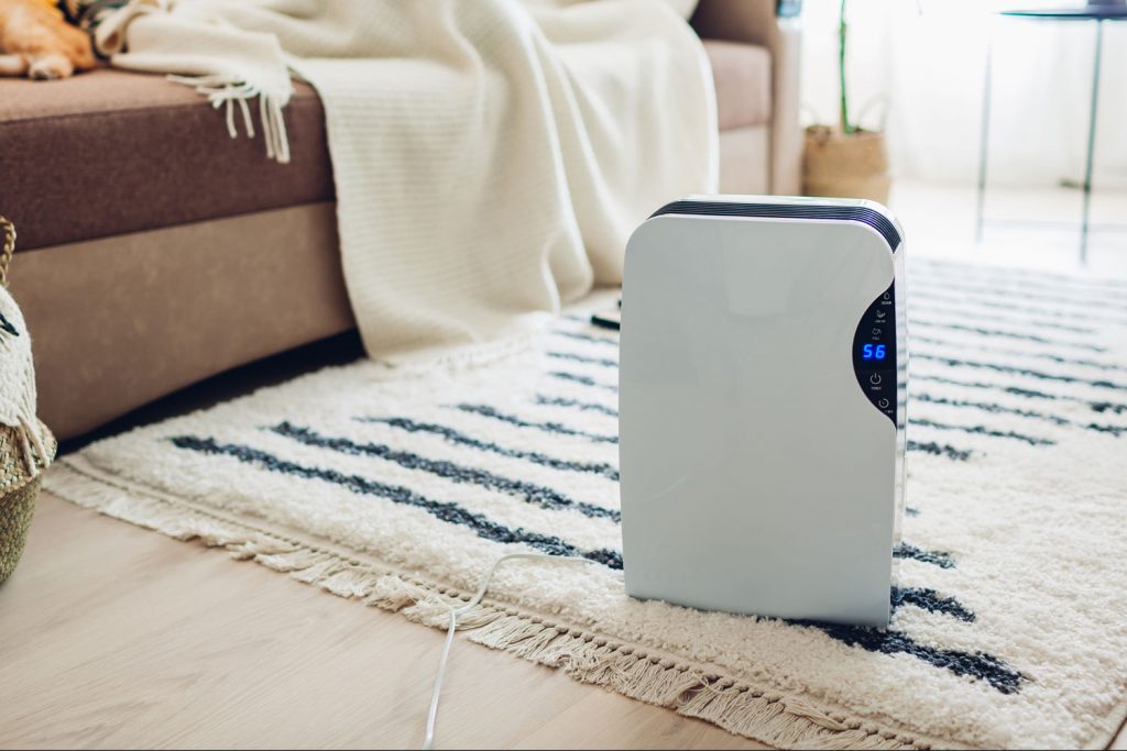 A white digital display Dehumidifier placed in the carpet