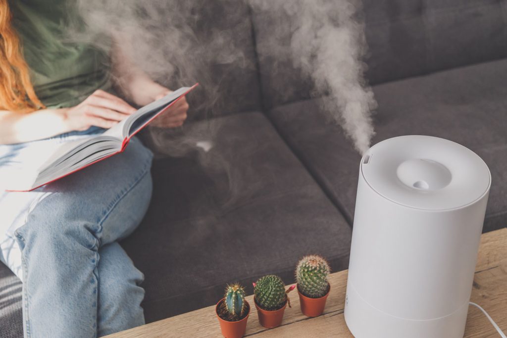 A woman reading her book next to the humidifier