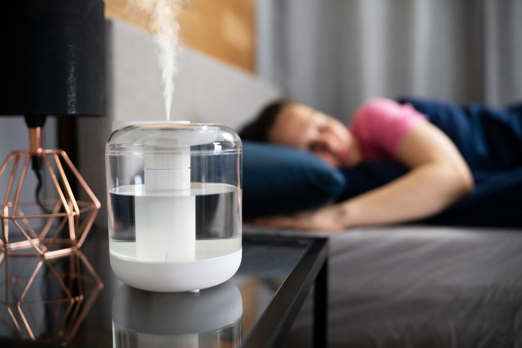 Air Humidifier Steam On Nightstand Near Young Lady Sleeping