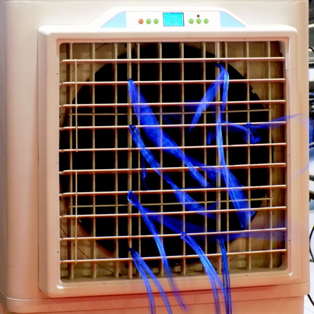 An air conditioning unit with blue ribbons attached at the grills