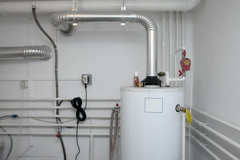 A white boiler with pipes running all over the walls