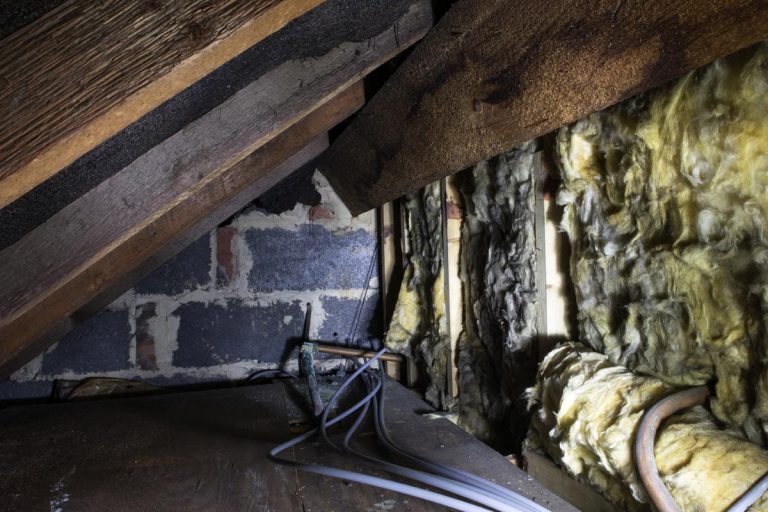 Crawl space under the eves of a house showing old fibreglass insulation, How To Insulate Crawl Space Walls