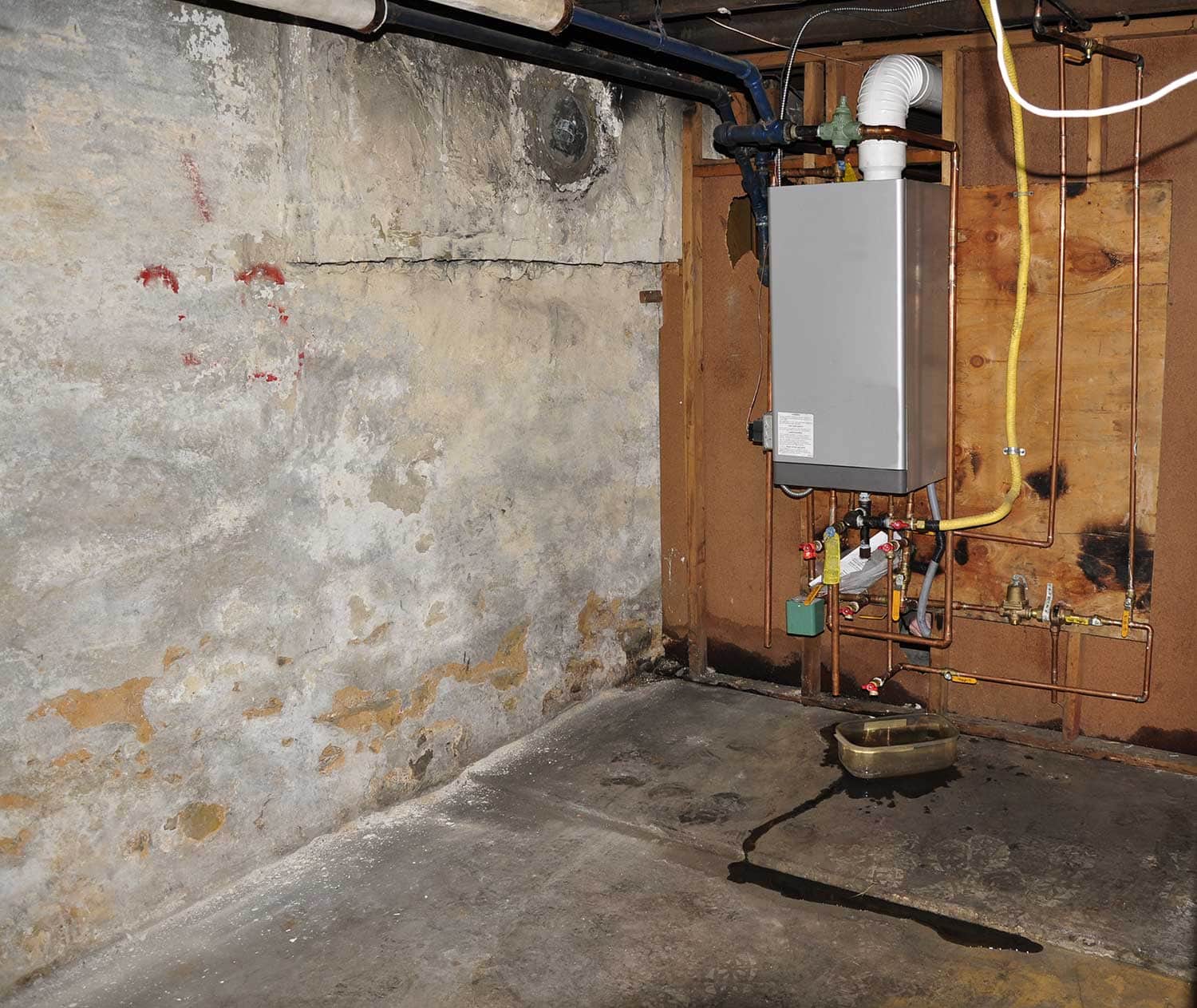 Furnace heating unit on wall in an old basement