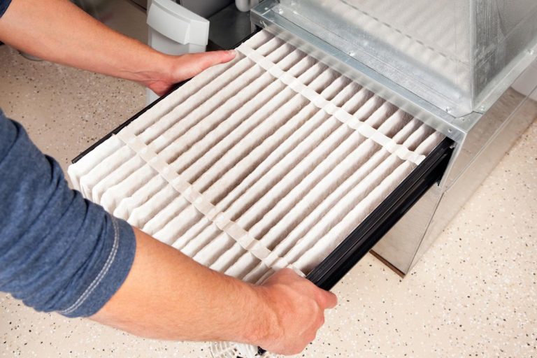Male are installing a furnace air filter, Should Your Furnace Filter Stick Out?
