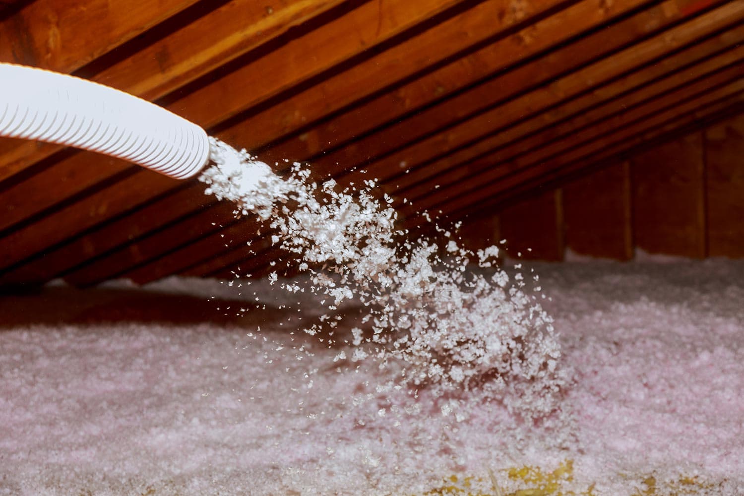 Spraying blown fiberglass insulation for roof